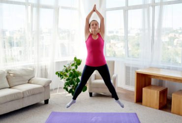 Young woman doing jumping exercise at home
